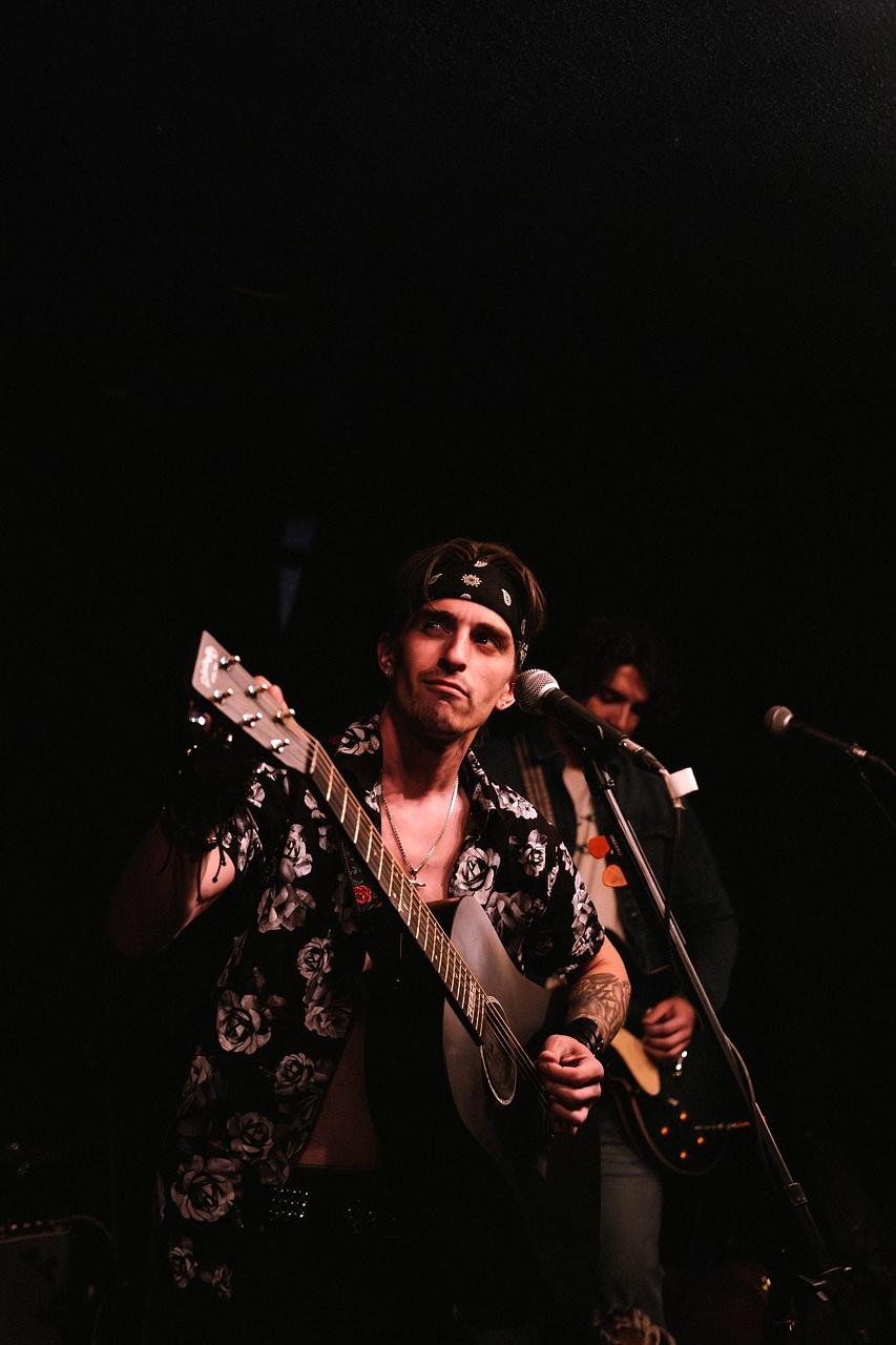 Sängerin singt mit Akustikgitarre auf der Bühne