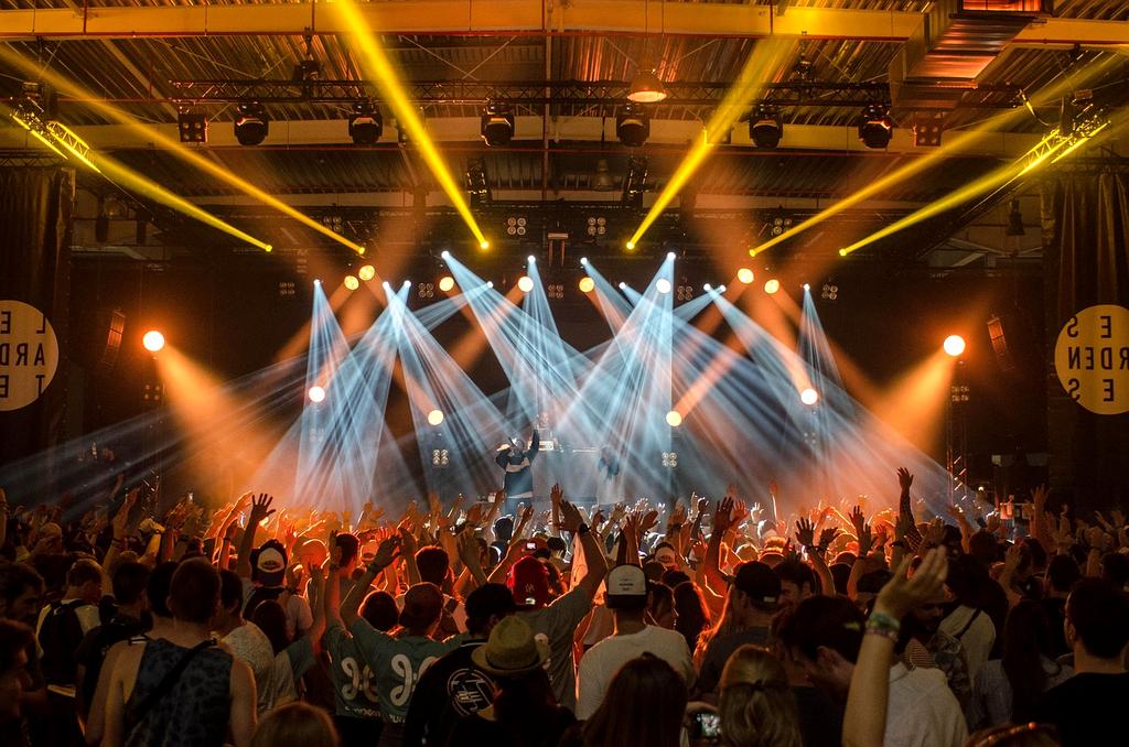 Open-air Konzert mit jubelnder Menge und bunten Lichtern